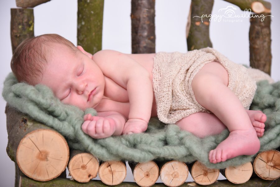 Baby auf Holzbank schläft auf Kuscheldecke